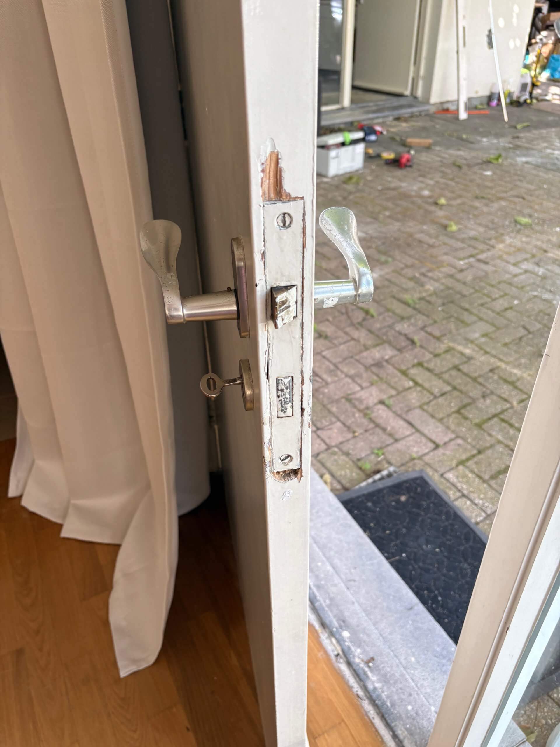 IMG_7981 Geopende deur van een woning met stoeptegels erachter
